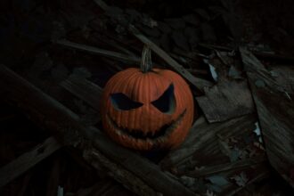 a carved pumpkin on a log